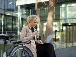 Nainen työskentelee kannettavalla tietokoneellaan helsinkiläisessä miljöössä