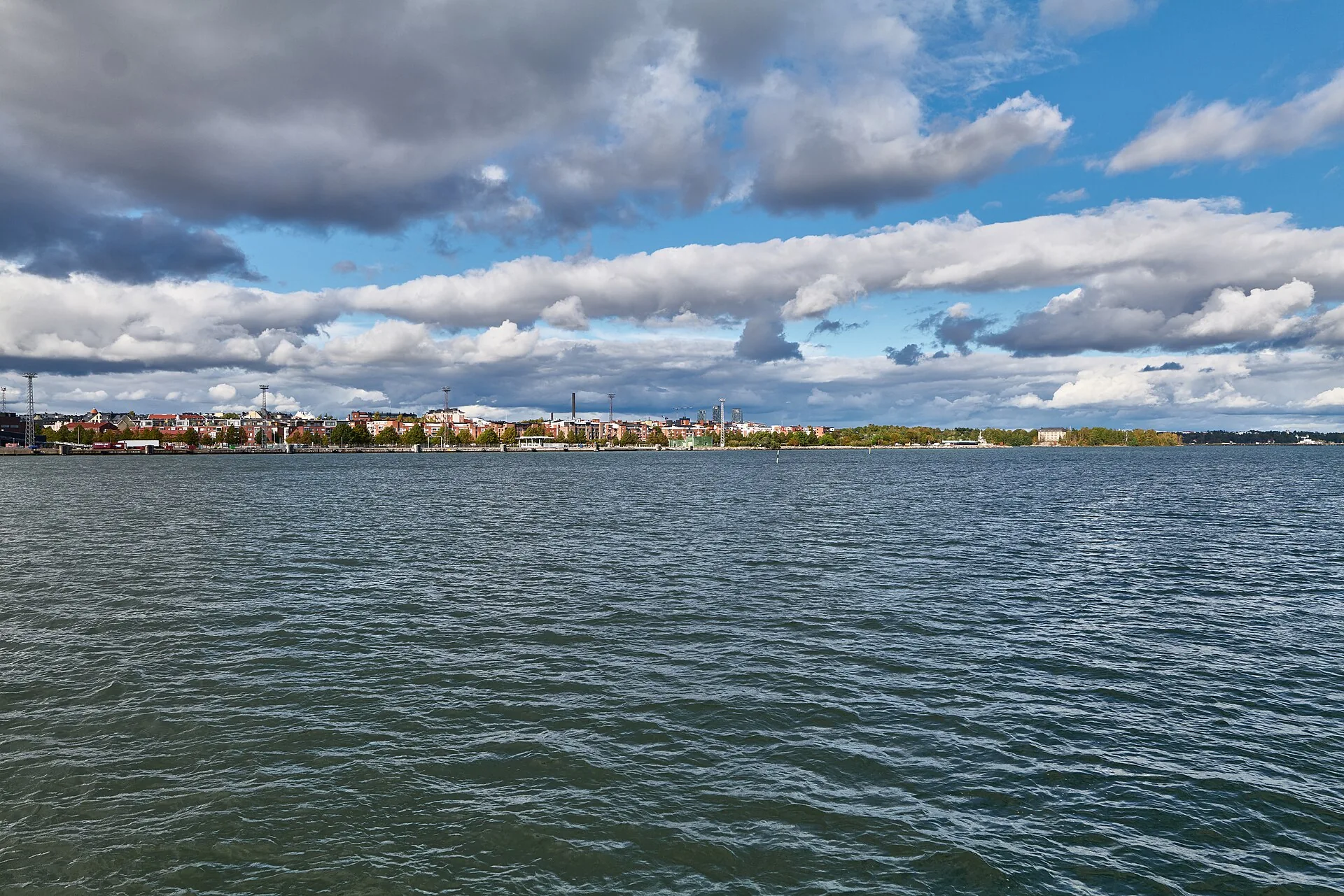 Kirkkovene soutamassa Helsingin rannikolla Katajanokan suuntaan