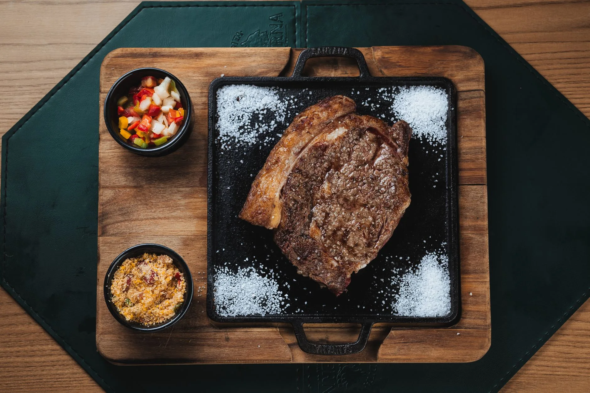 Grillattu ribeye-pihvi valurautapannulla lisukkeiden kanssa pihviravintolan tapaan