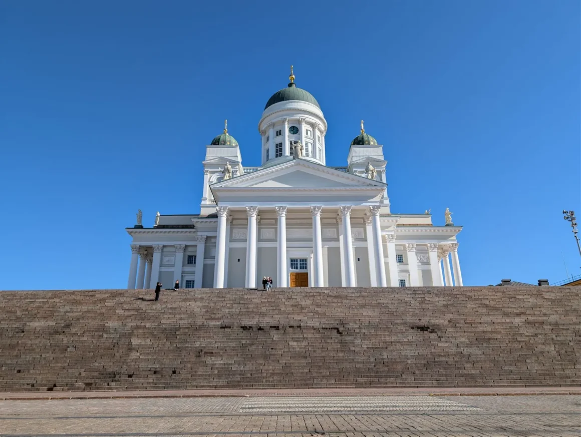 Helsingin tuomiokirkko ja leveät portaat Senaatintorilla kirkkaan sinistä taivasta vasten
