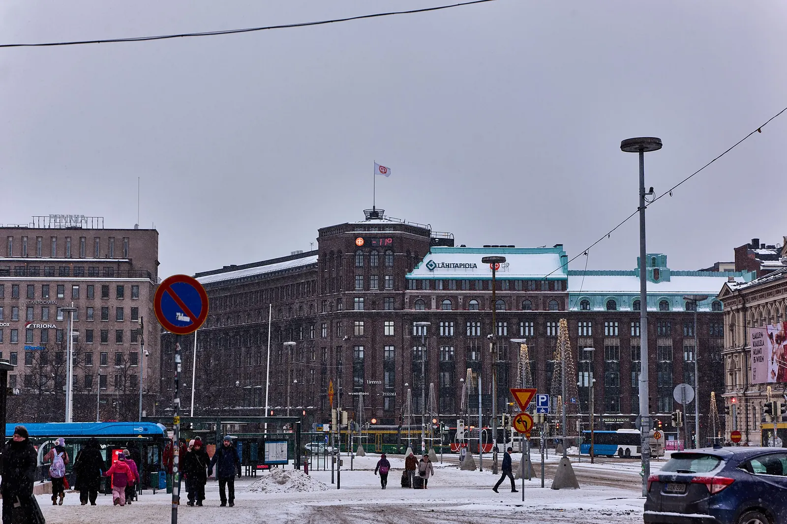 HSL-bussi ajaa lumisateessa Rautatientorin ohi Helsingin keskustassa