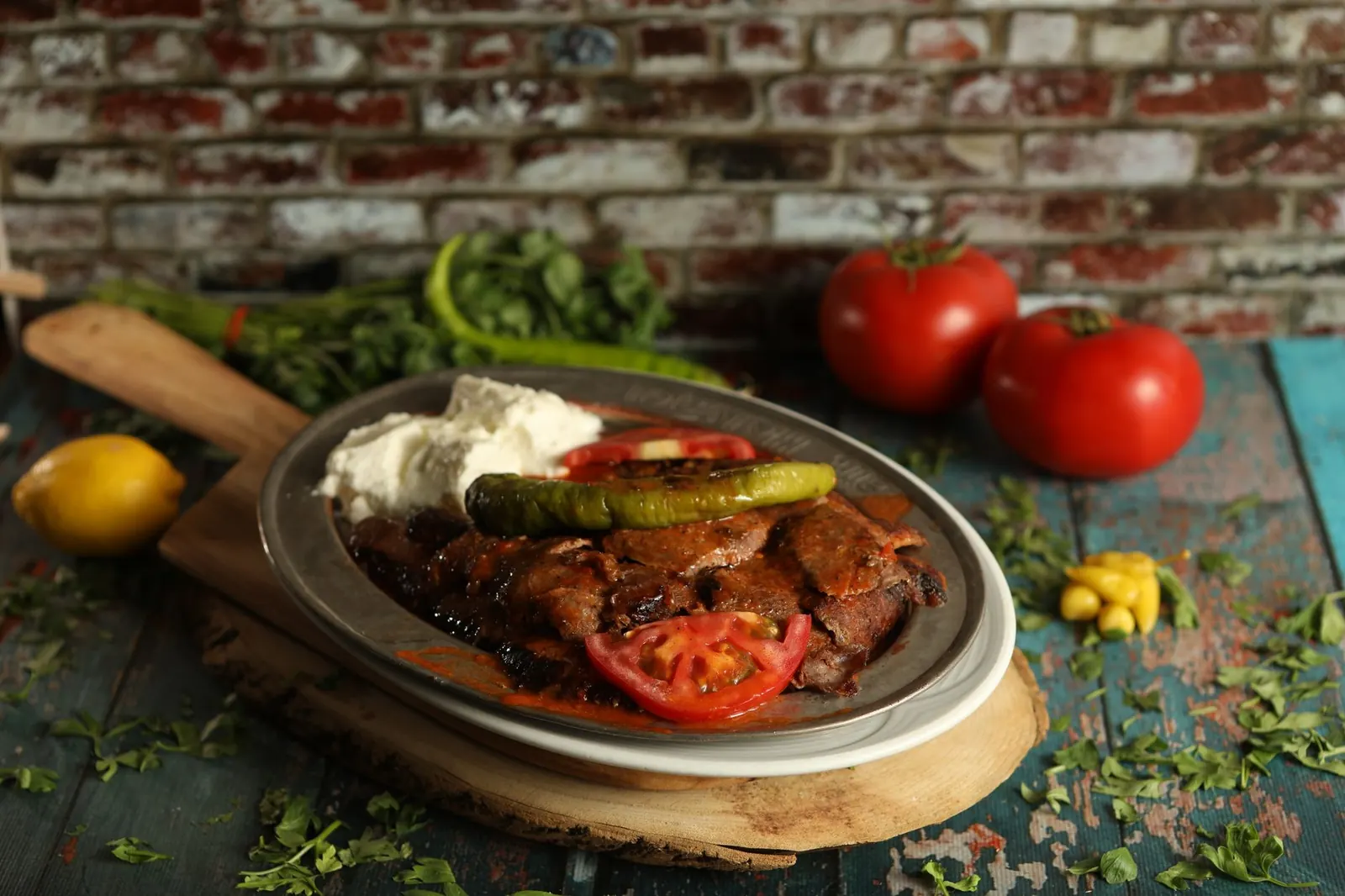 Iskender-kebab tomaattikastikkeella, jogurtilla ja grillatulla paprikalla