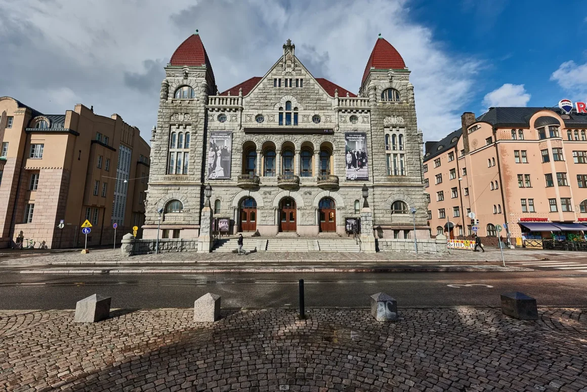 Kansallisteatterin graniittijulkisivu torneineen ja kaariportteineen Helsingin Rautatientorin laidalla