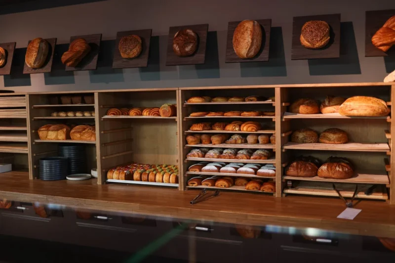 Leipomon myymälä, jossa tiskin hyllyillä leipiä, croissanteja ja leivonnaisia