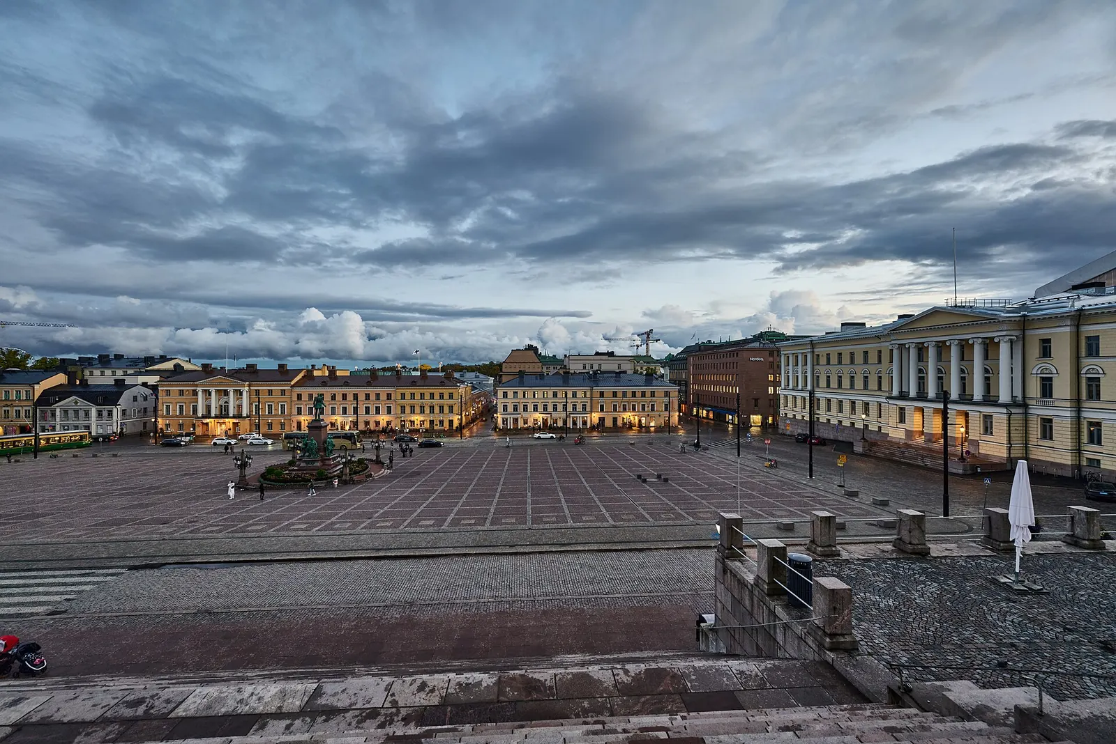 Senaatintori Helsingin Kruununhaassa iltahämärässä pilvisen taivaan alla